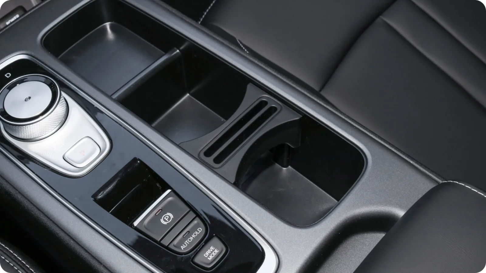 Console central do GAC AION ES — seletor rotativo e porta-copos